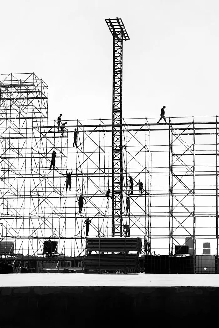 about-02 Silhouetted workers on scaffolding against the sky, depicting urban construction dynamics.